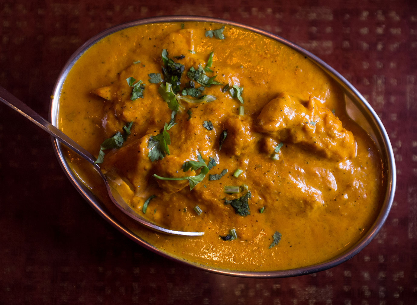 Butter chicken in a silver dish.