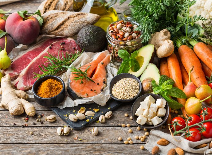 Colorful fruits, vegetables, meats, cheeses, and fish displayed on a tabletop