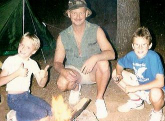 childhood photo of Justin camping with family